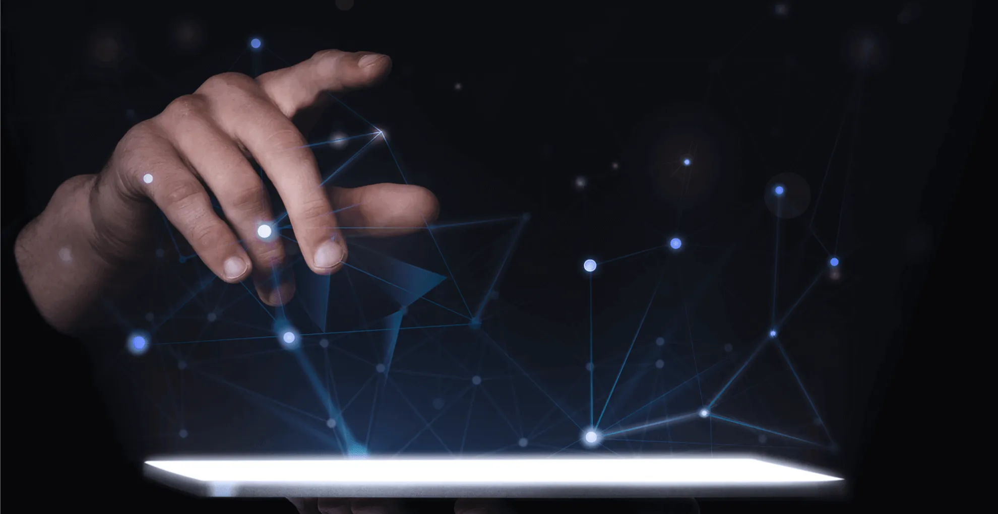 Karanlık zeminde bir tabletin üzerinde beliren, ışıklı düğüm ve çizgilerden oluşan mavi ağ grafiğine dokunan el